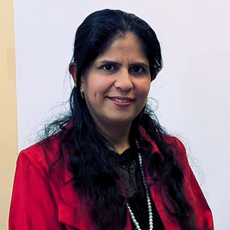 Professional portrait of Mani Bhandari in a red blazer